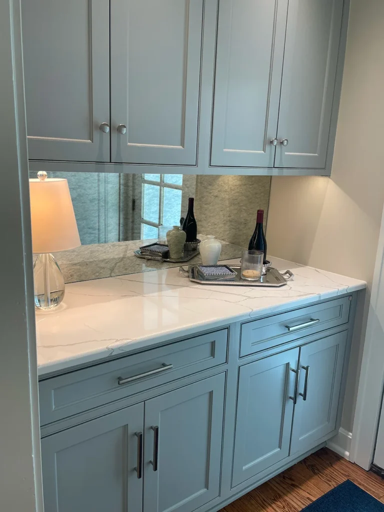 Gray cabinetry with marble countertop and mirror backsplash by Stag Homes Design-Build in Kansas City