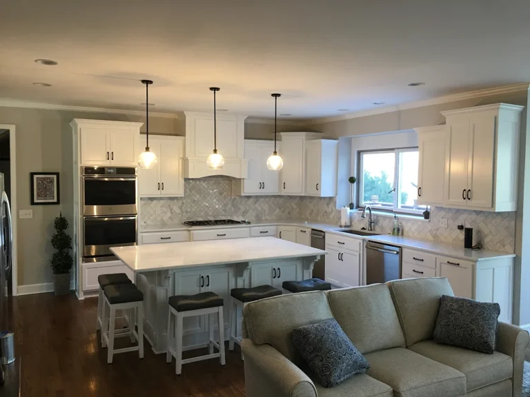 White kitchen with large island, pendant lighting, and stainless steel appliances by Stag Homes Design-Build in Kansas City